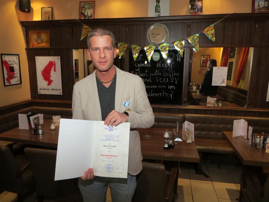 Gastronom Manuel Schmidt mit seiner Ehrenmedaille und Urkunde für die Aktion Together